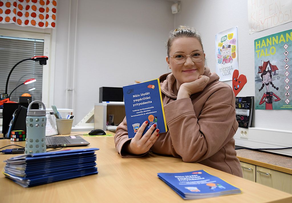 annika kartano työkirja kädessä, kuvaajana mika pulkkinen